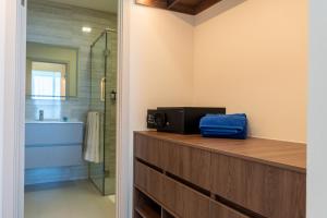 a bathroom with a shower and a microwave on a counter at Condo Suite 2BR With View in Panama City