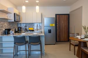 a kitchen with a bar with chairs and a table at Condo Suite 2BR With View in Panama City