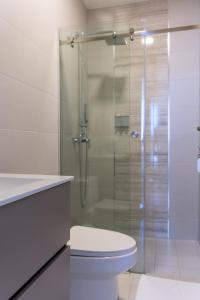 a bathroom with a toilet and a glass shower at Condo Suite 2BR With View in Panama City +5 photos