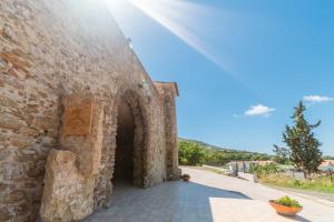 an alley in a stone wall with the sun shining at B&B Nonno Armando in Torchiara