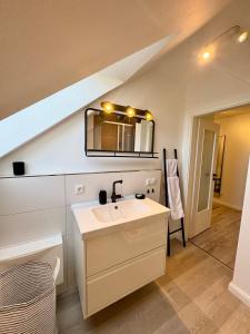 a bathroom with a sink and a mirror at Vollmöbliertes Apartment am Deich in Neuendeich