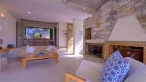 a living room with a fireplace and a couch at Villa Petra in Arvanitakaíïka