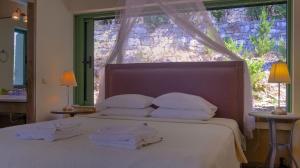 a bedroom with a bed with towels on it at Villa Petra in Arvanitakaíïka