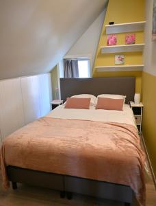 a bedroom with a large bed with two pillows at Huis van de Koekuit in Moorslede