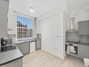 a kitchen with white counters and a large window at London Duo & Quad Rooms in Zone 2 - Willesden Green in London