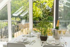a white table with plates and glasses and a window at Walnut Flats-F3, 1-Bedroom with Stunning Garden View, AC, Parking, Netflix, WIFI - Close to Oxford, Bicester & Blenheim Palace in Oxford