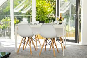 a dining room with a white table and two white chairs at Walnut Flats-F3, 1-Bedroom with Stunning Garden View, AC, Parking, Netflix, WIFI - Close to Oxford, Bicester & Blenheim Palace in Oxford +24 photos