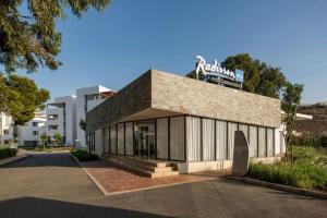 a building with a sign on the top of it at Apparemment à Radisson Blu Apartment Alhoceima Beach Access in Al Hoceïma