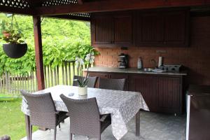 a table and chairs on a patio with a kitchen at Ciprus nyaraló in Szarvas