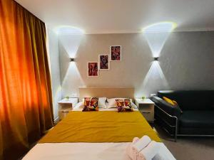 a bedroom with a yellow bed and a couch at Halqyma Hotel in Oral
