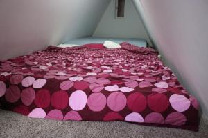 a bed with pink and pink hearts on it at Ciprus nyaraló in Szarvas