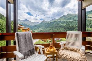 a balcony with two chairs and a view of mountains at Résidence Pierre & Vacances Les Sentiers du Tueda in Méribel +50 photos