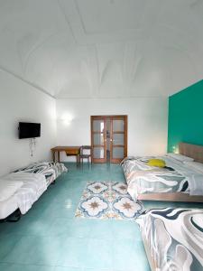 a room with three beds and a table in it at Nonna Liberina in Procida