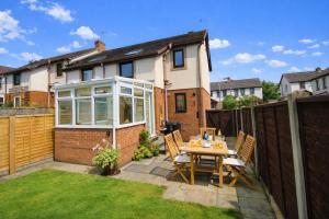 a patio with a table and chairs in a backyard at Beckside Garden Brampton, ideal family cottage close to Hadrians Wall in Brampton