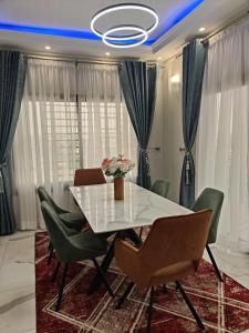 a dining room with a white table and chairs at Nguem's Appart in Odza I