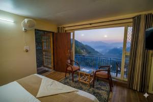 a bedroom with a bed and a balcony with a view at Mountain Golden Ray in Mukteshwar