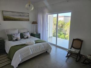 a bedroom with a bed and a sliding glass door at Hartsepunt Seesig in Hartenbos