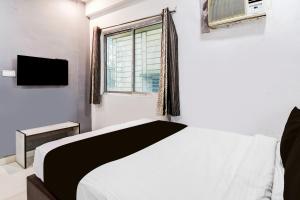 a bedroom with a bed and a window and a tv at Hotel O CITY INN in Kolkata
