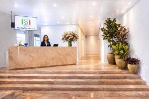 a woman standing at a counter in a lobby at Hotel Pex Mantova in Mantova