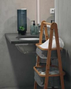 Eine Holzleiter steht vor einem Waschbecken im Badezimmer. in der Unterkunft Casas do Vale - T1 in Nordeste