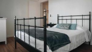 ein Schlafzimmer mit einem großen Bett mit schwarzem Rahmen in der Unterkunft Casas do Vale - T1 in Nordeste
