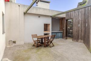 eine Terrasse mit einem Holztisch und Stühlen in der Unterkunft Casas do Vale - T1 in Nordeste