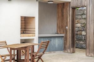 eine Küche mit einem Holztisch und Stühlen in der Unterkunft Casas do Vale - T1 in Nordeste