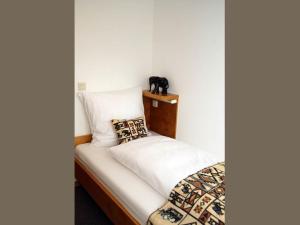 a small bed with a black cat on a shelf at Restaurant-Hotel Haus Mühlenbrock in Schermbeck