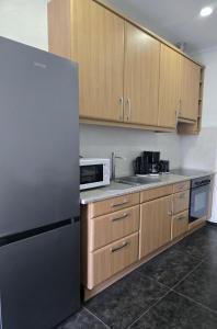 a kitchen with wooden cabinets and a stainless steel refrigerator at Leinstraße Ferienwohnung Neustadt in Neustadt am Rübenberge