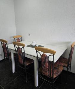 a white table with chairs and a tea pot on it at Leinstraße Ferienwohnung Neustadt in Neustadt am Rübenberge +7 photos