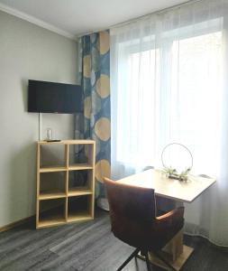 a room with a table and a chair and a window at Leinstraße Ferienwohnung Neustadt in Neustadt am Rübenberge