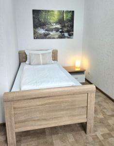 a bedroom with a large bed with a night stand at Leinstraße Ferienwohnung Neustadt in Neustadt am Rübenberge