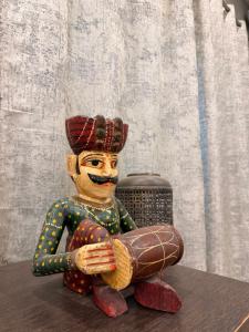 a statue of a man sitting on a table at The Machan Farmhouse in Noida
