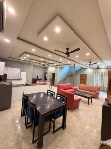 a living room with a table and a couch at The Machan Farmhouse in Noida