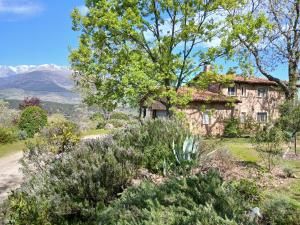an old house on a hill with trees and flowers at Finca Bellavista de Gredos in Madrigal de la Vera