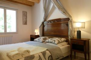 1 dormitorio con cama con dosel y toallas. en Nature & Chateaux, en Villandry