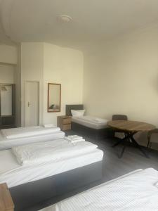 a room with several beds and a table and chairs at Hotel Aster an der Messe in Berlin +29 photos