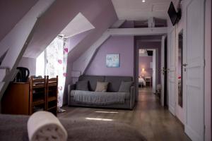 a living room with purple walls and a couch at Logis Hotels - Auberge de l'Île - Hôtel 3 étoiles et Restaurant in Creysse
