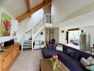 a living room with a blue couch and a table at Villa Tulp & Duin in Julianadorp