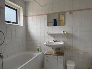 a bathroom with a tub and a sink and a bath tub at Villa Tulp & Duin in Julianadorp +28 photos