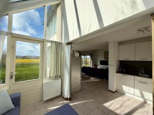 a kitchen and living room with a sliding glass door at Villa Tulp & Duin in Julianadorp