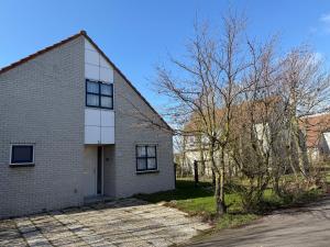 a white brick house on a street at Villa Tulp & Duin in Julianadorp