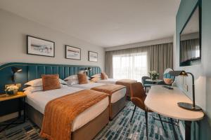 a hotel room with two beds and a table at Waterford Viking Hotel in Waterford