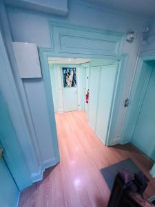 an empty hallway with blue walls and wooden floors at Hôtel De La Cathédrale in Reims +42 photos