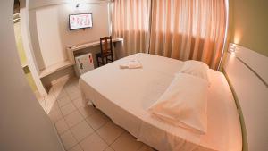 a small room with a bed and a chair in it at Sir Hotel in Telêmaco Borba