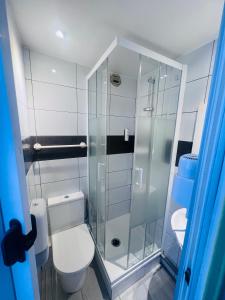 a bathroom with a toilet and a glass shower at Hôtel De La Cathédrale in Reims