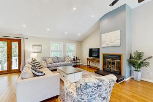 a living room with a couch and a fireplace at Sandy Feet Retreat in Kill Devil Hills