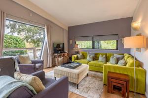a living room with a green couch and chairs at Abbey in Richmond
