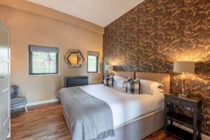a bedroom with a bed and a wall covered in wallpaper at Abbey in Richmond