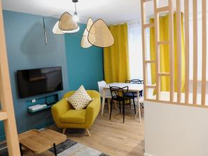 a living room with a yellow chair and a table at Le Mans Cosy in Le Mans